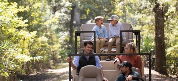 Family of 4 taking a guided tour through the woods in a jeep