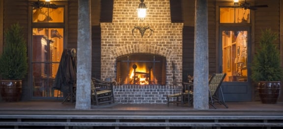 The Broadfield Lodge Front Porch, a large modern cabin with terrace and large brick fireplace.