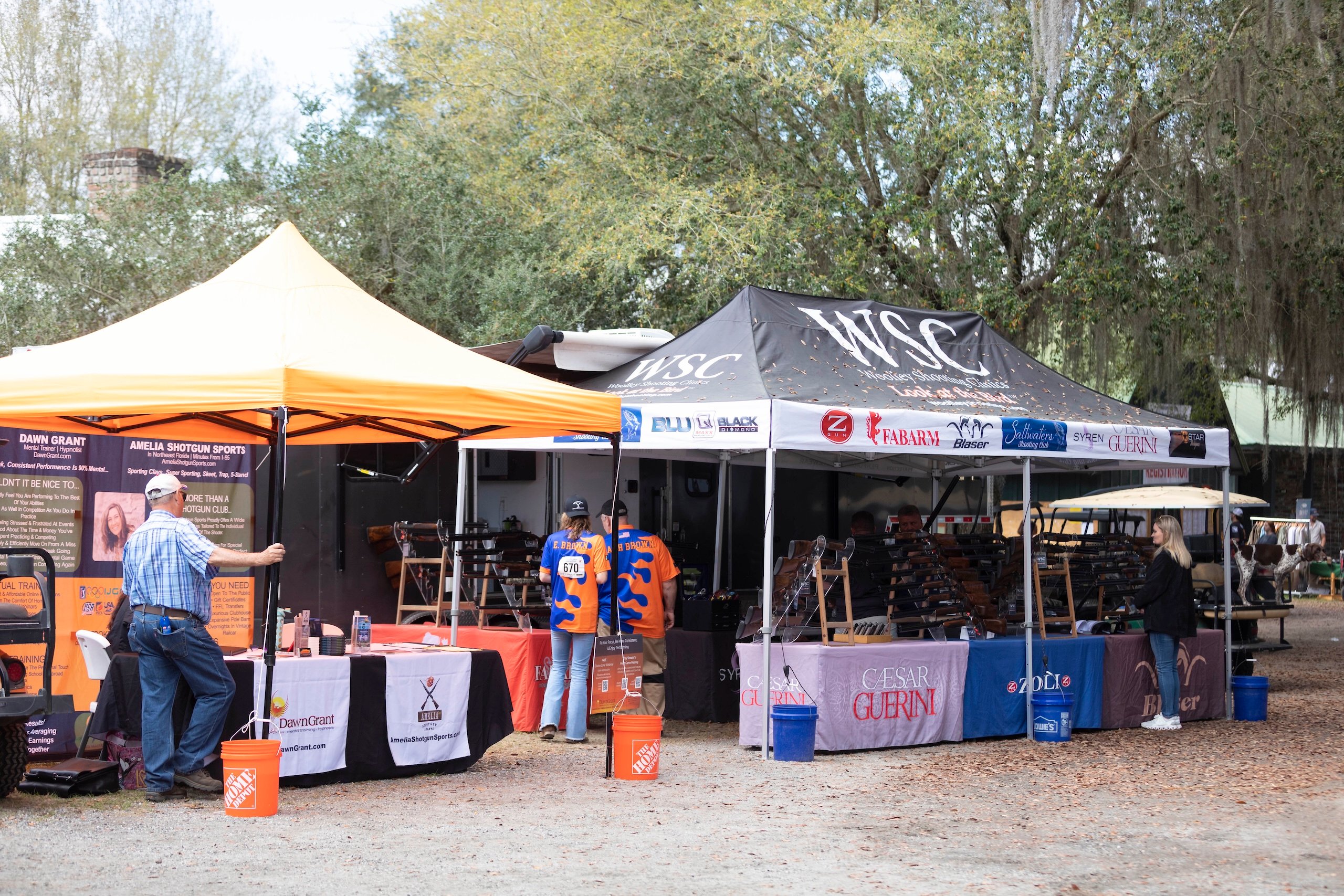 The vendor area of the Seminole Cup featuring a few assorted vendor tents and people looking at items for sale.