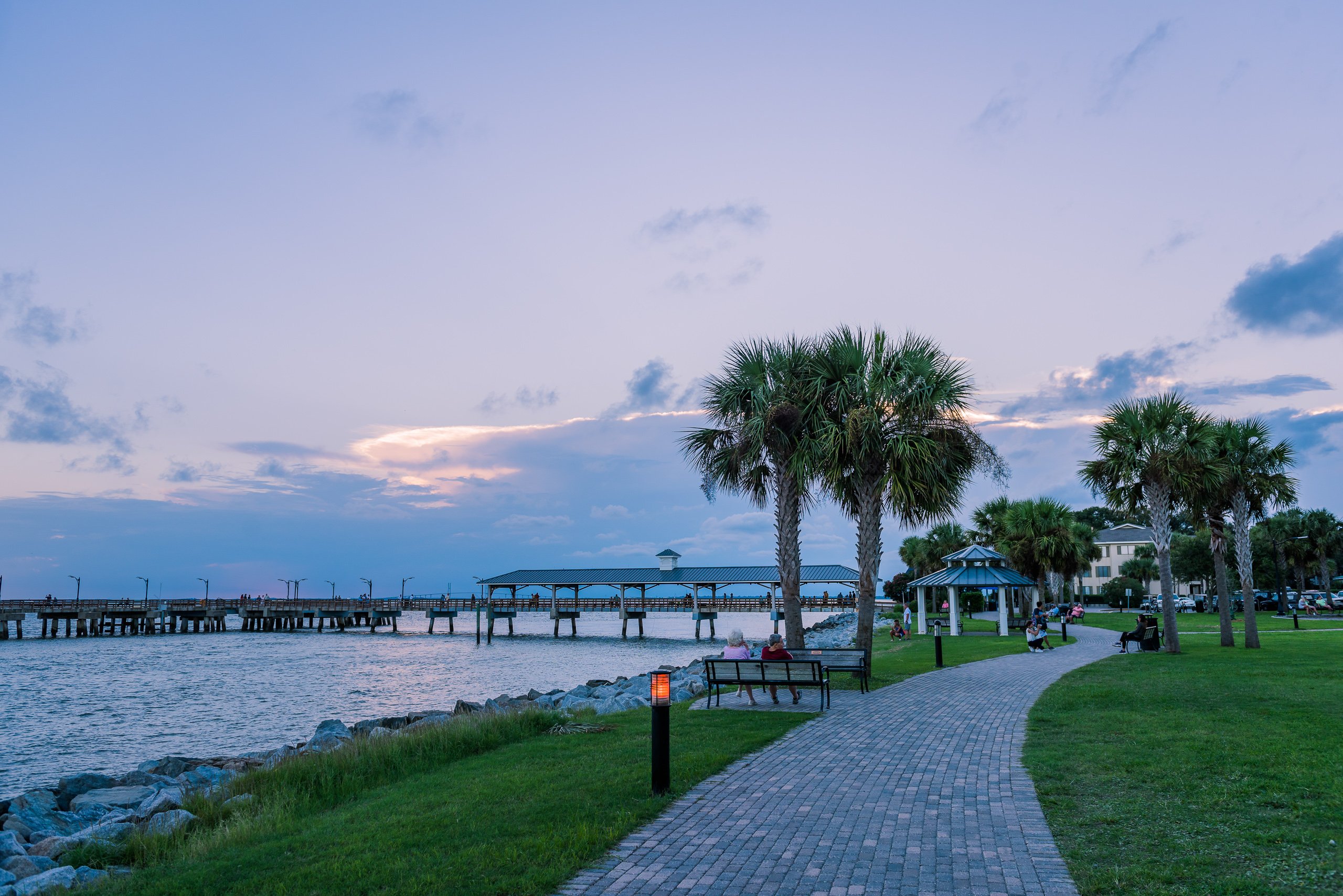 A walking path along a pier at sunset.