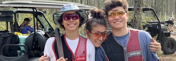 A woman and two boys smiling for a photo.